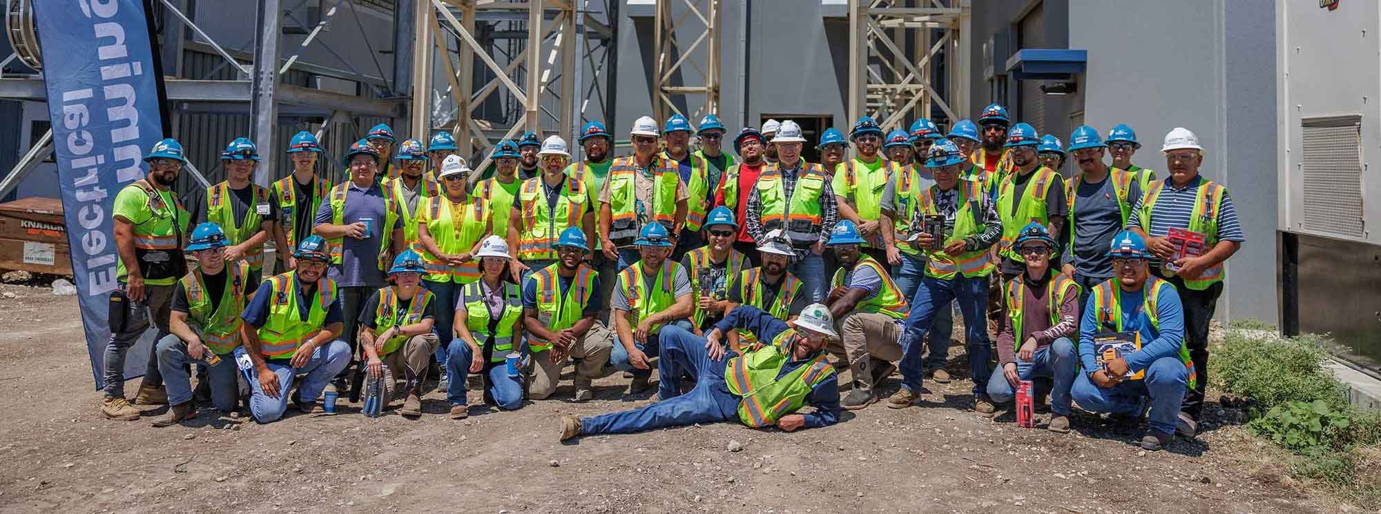 A group photo of electricians at a construction site A group photo of electricians at a construction site