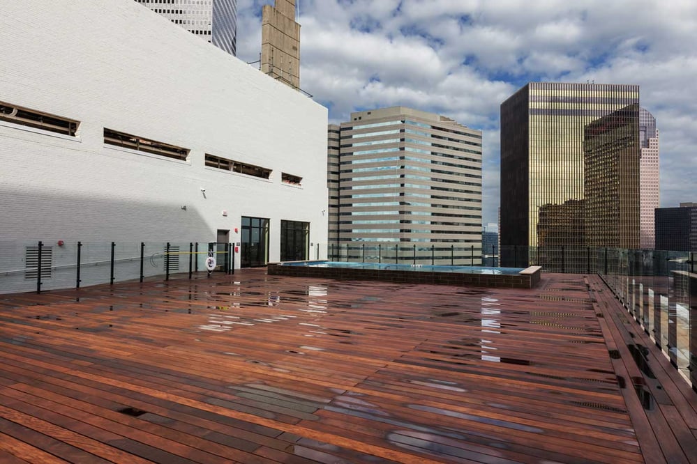 Rooftop view of a small pool surrounded by multiple high-rise buildings