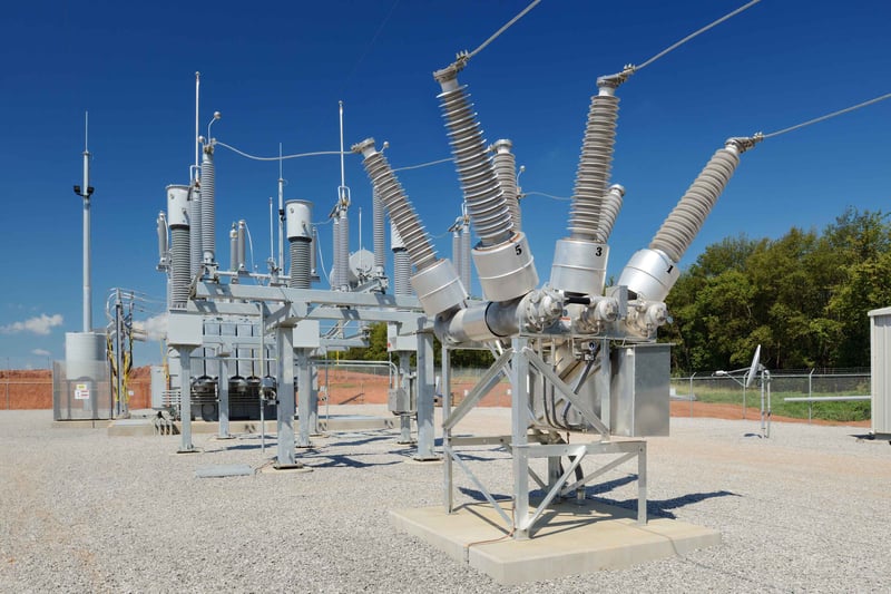 High-voltage electrical substation with equipment under a clear blue sky