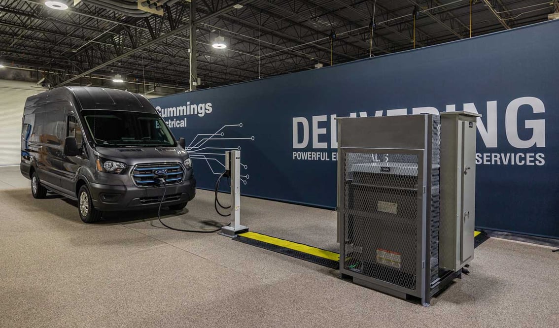 Interview view of an EV delivery van hooked into a charger connected to a prefabricated electrical skid