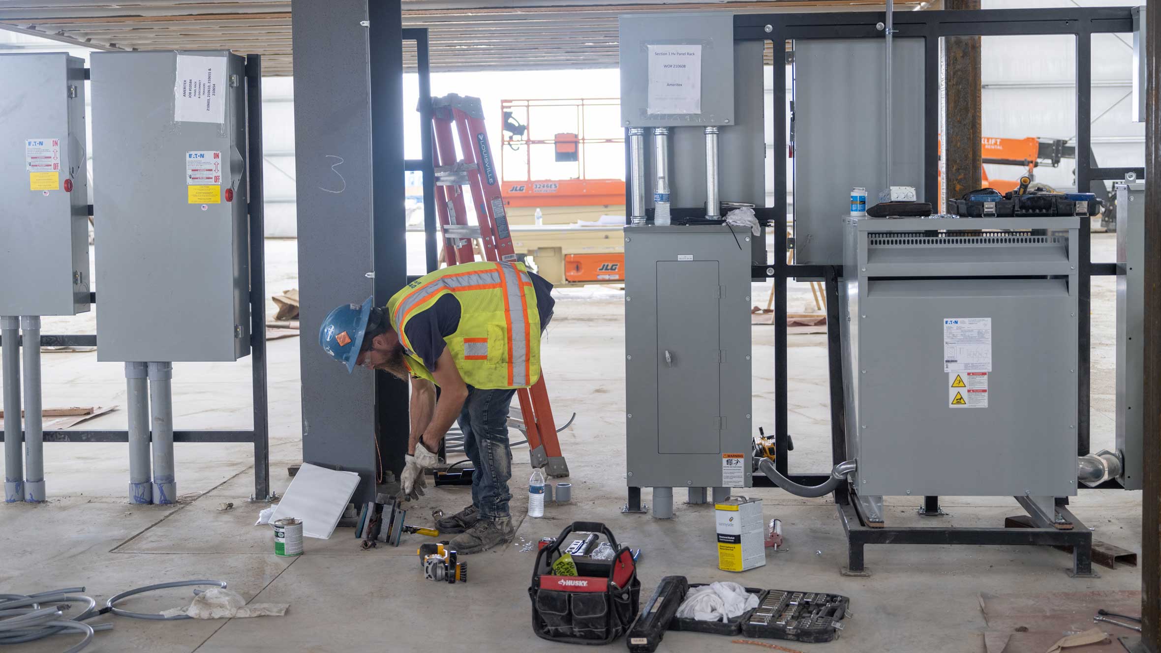 a Cummings technician grabbing equipment next to newly built electrical panels