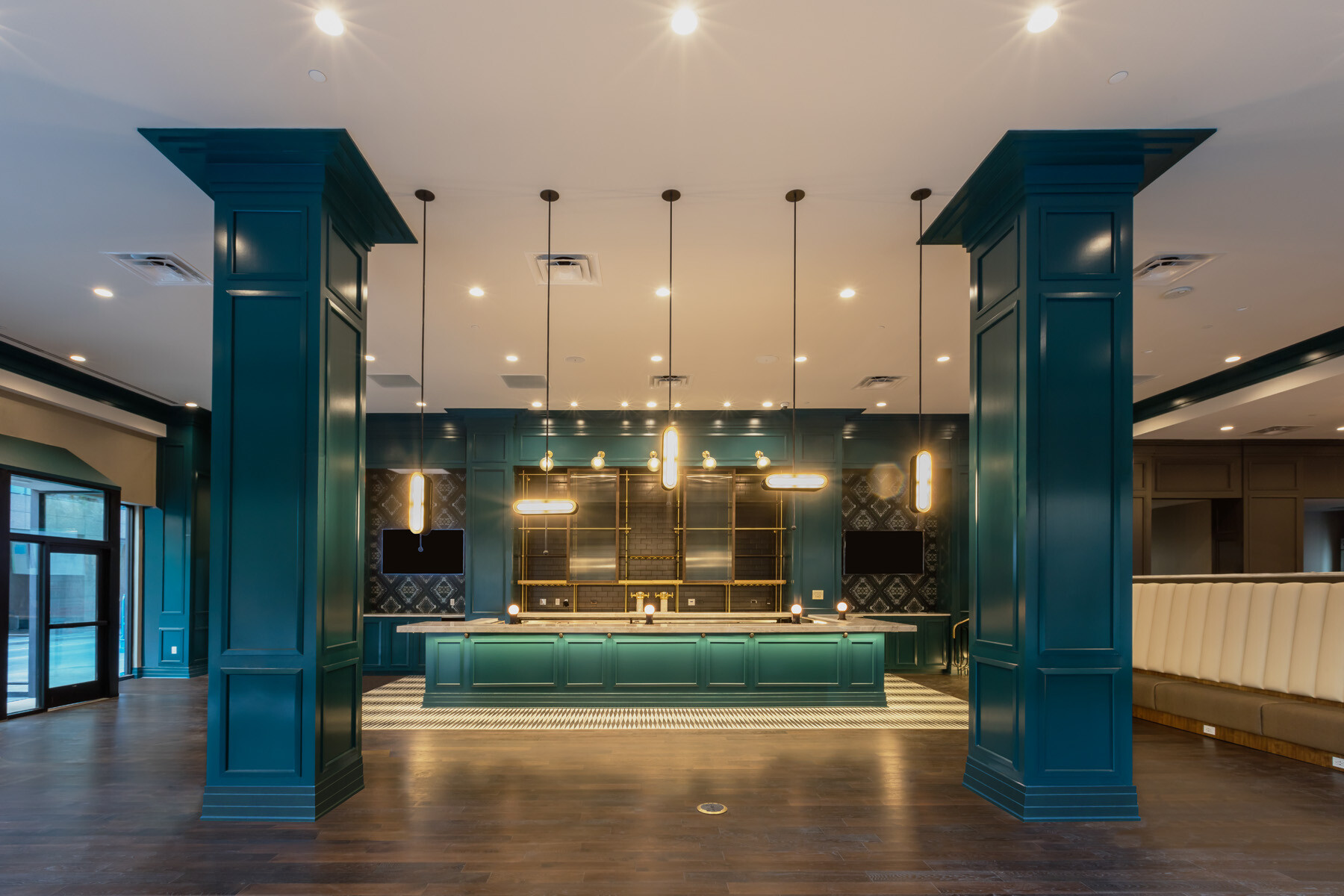 Modern interior of a hotel lobby area with teal-painted pillars and paneling