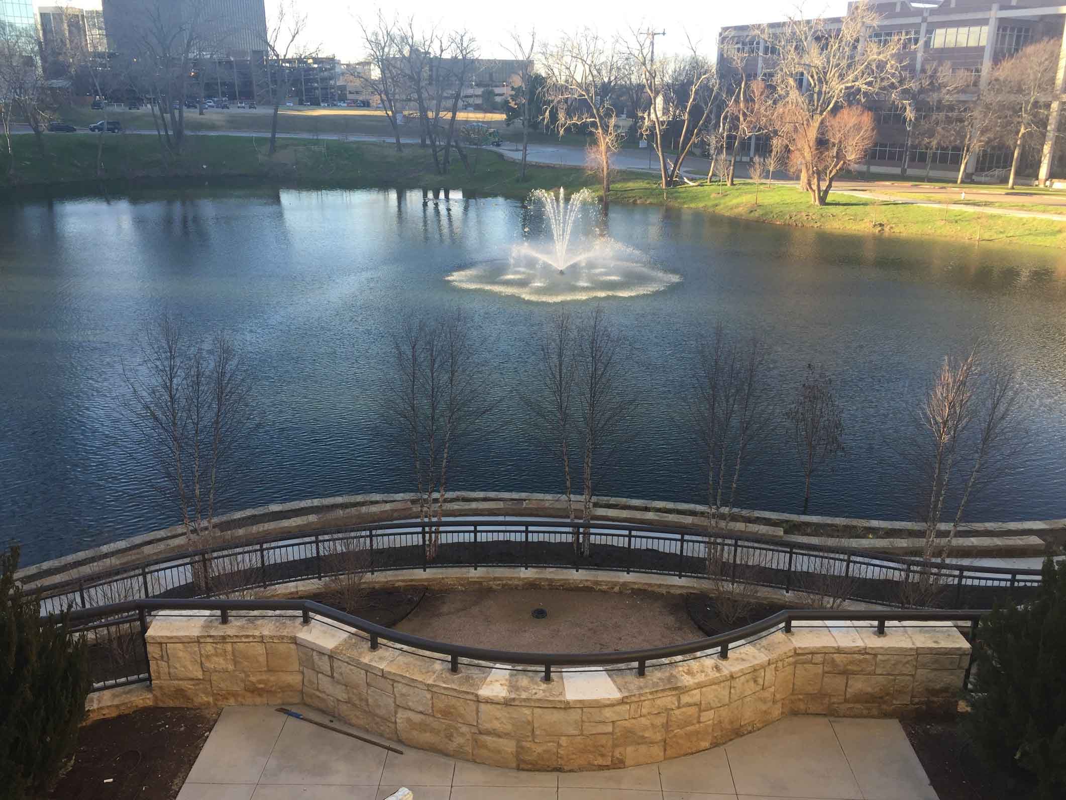 outdoor view of a pond with a fountain in middle