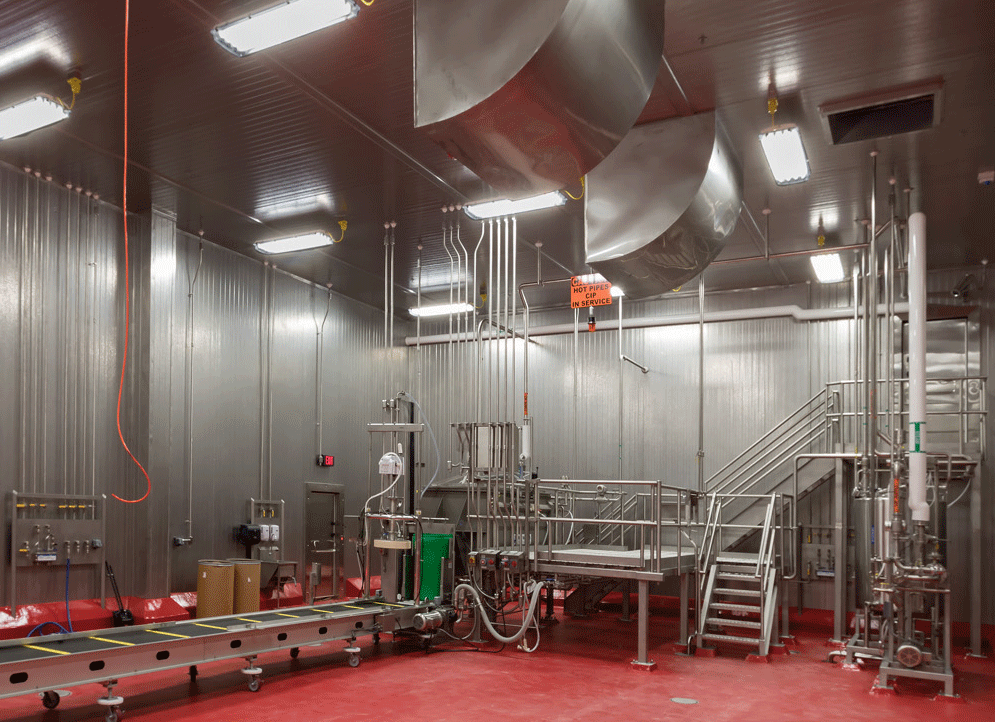 Indoor view of a food production facility with red flooring and metal ceiling and walls