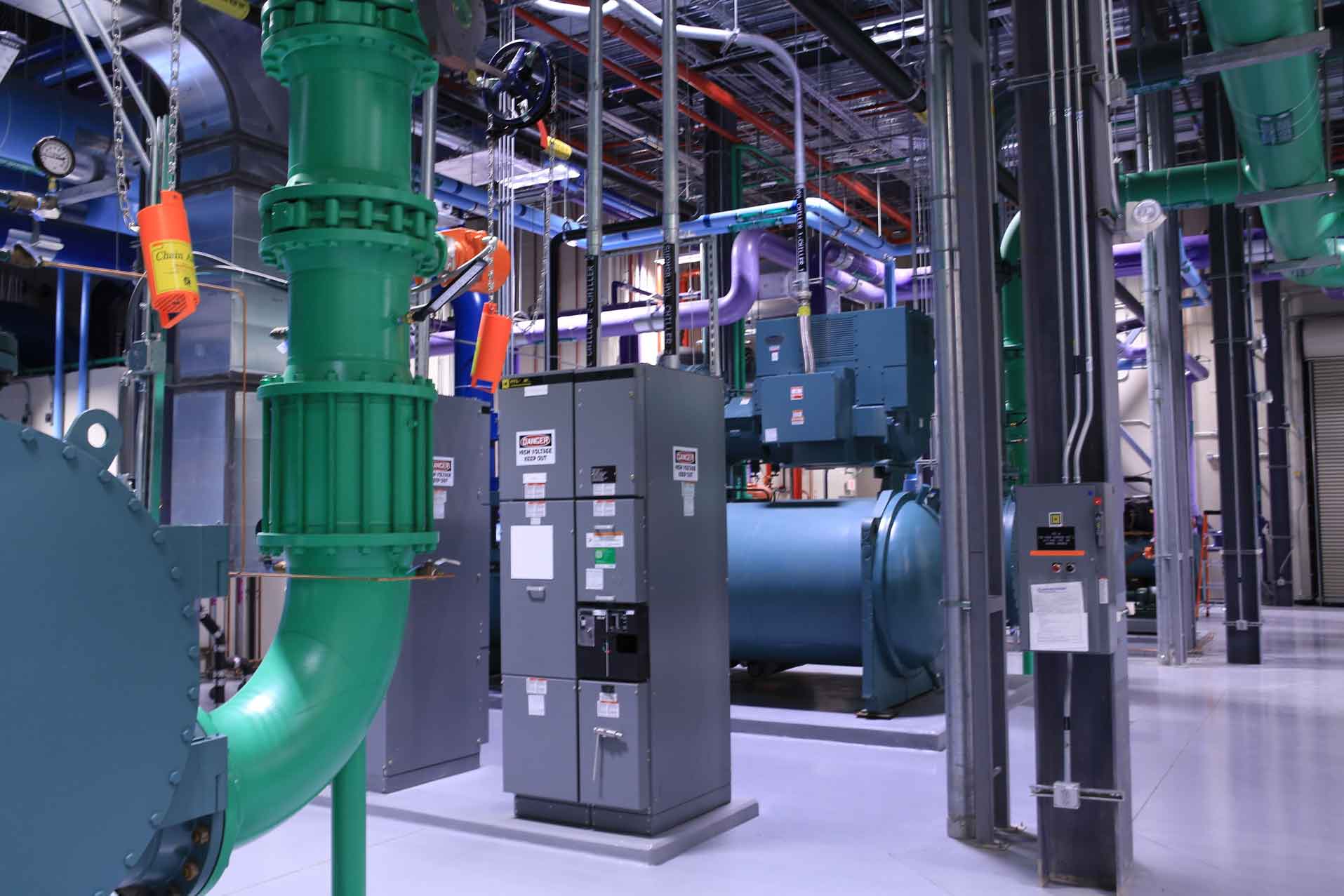 medical boiler room with colorful piping and gray electrical panels