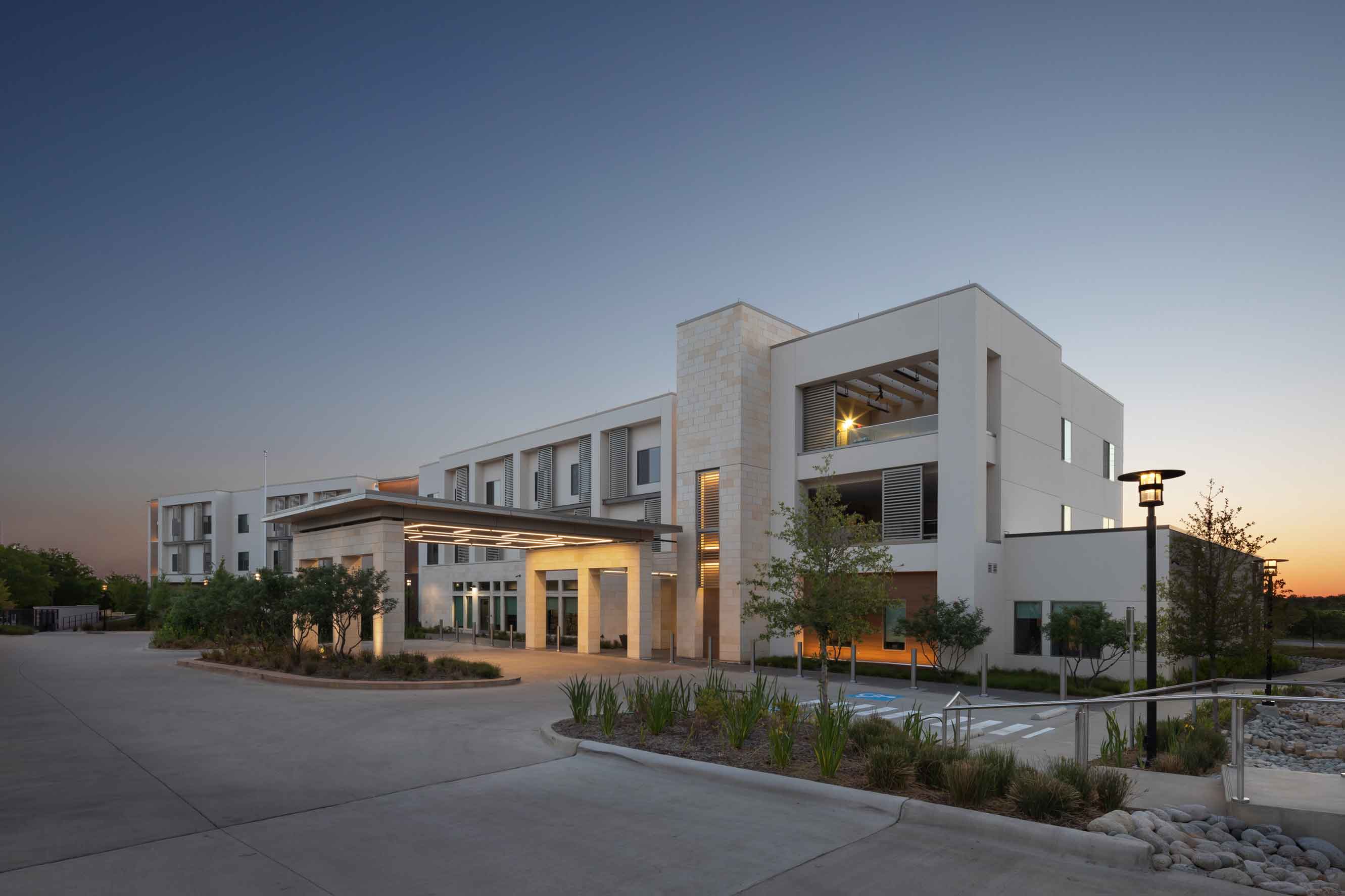 outdoor sunrise view of a hotel building with an illuminated front entrance