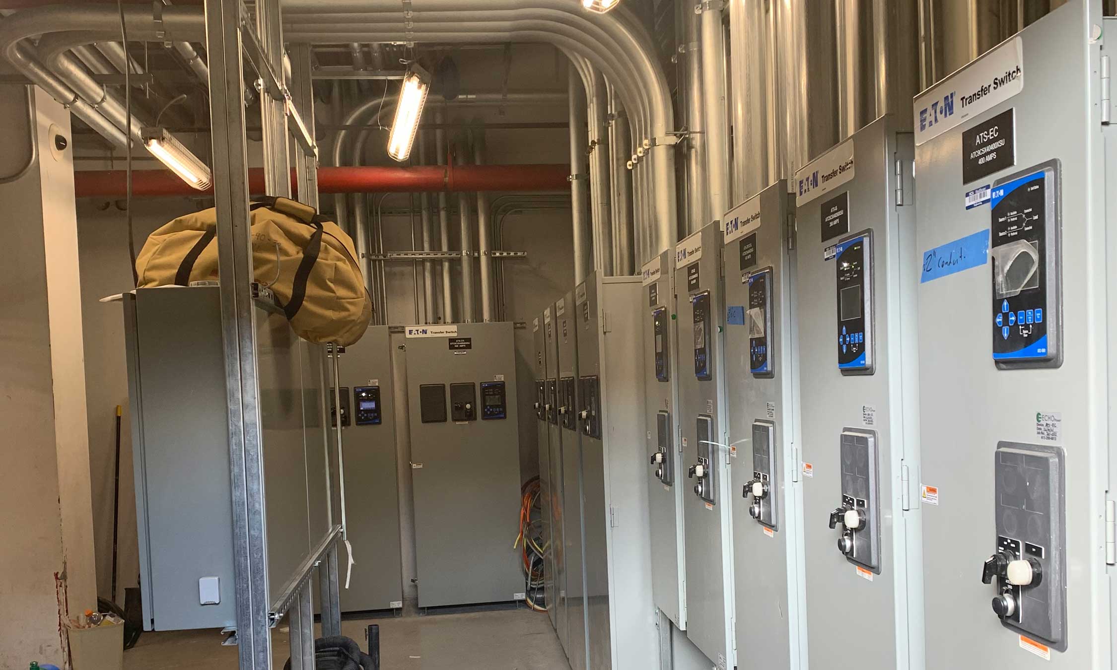 Interior view of an emergency power room showing detailed conduit work, electrical panels, and system controls in place