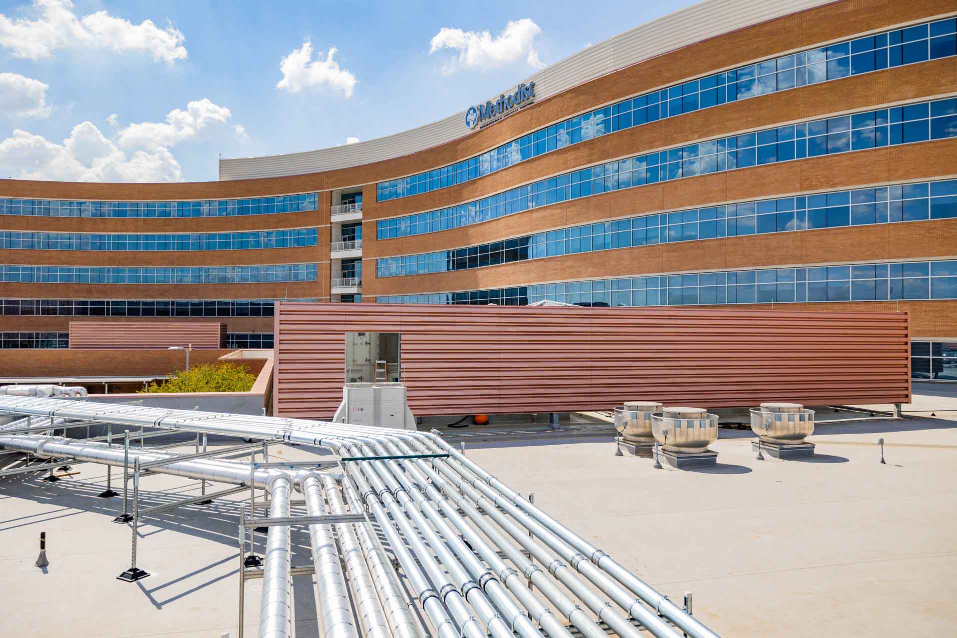Outdoor view of a Methodist medical center with large conduits and piping