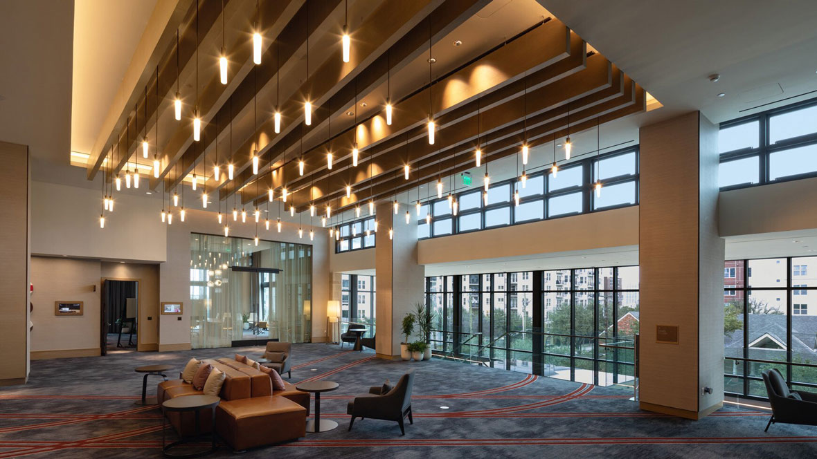 Interior of a contemporary lobby area of a hotel with rows of hanging ceiling lighting
