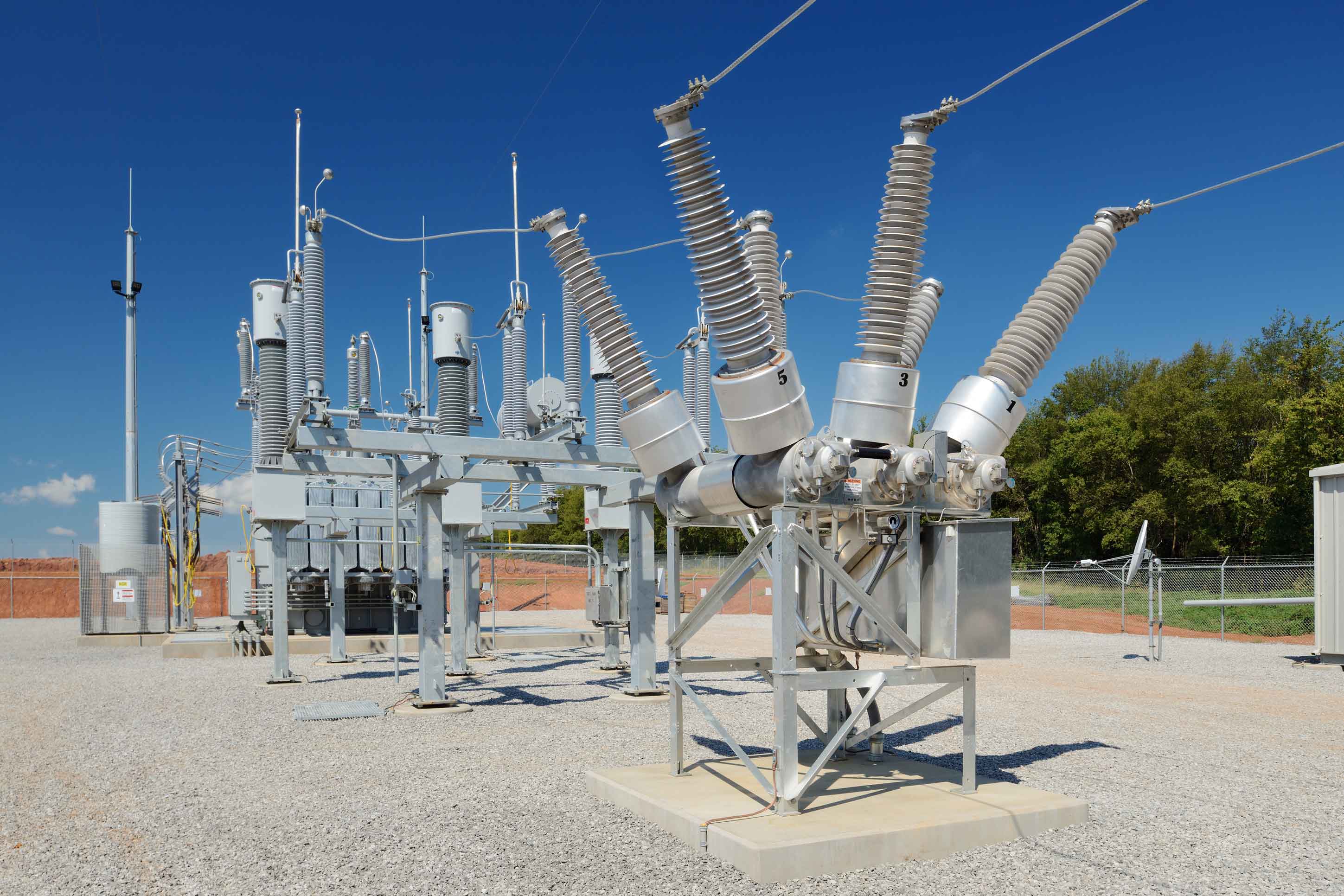 Close-up view of high-voltage substation equipment under a blue sky