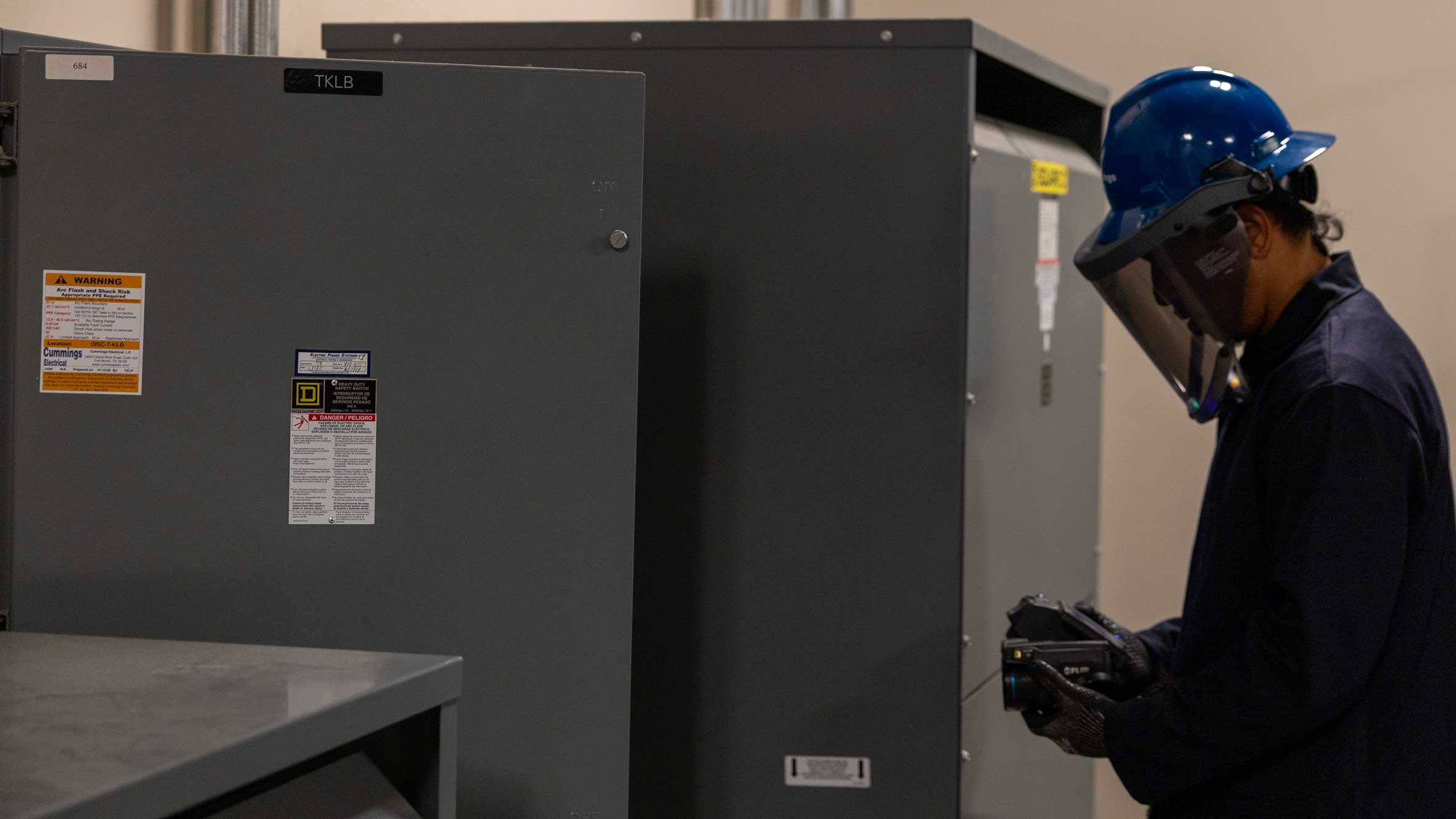 Cummings technician with PPE IR scanning inside an electrical panel