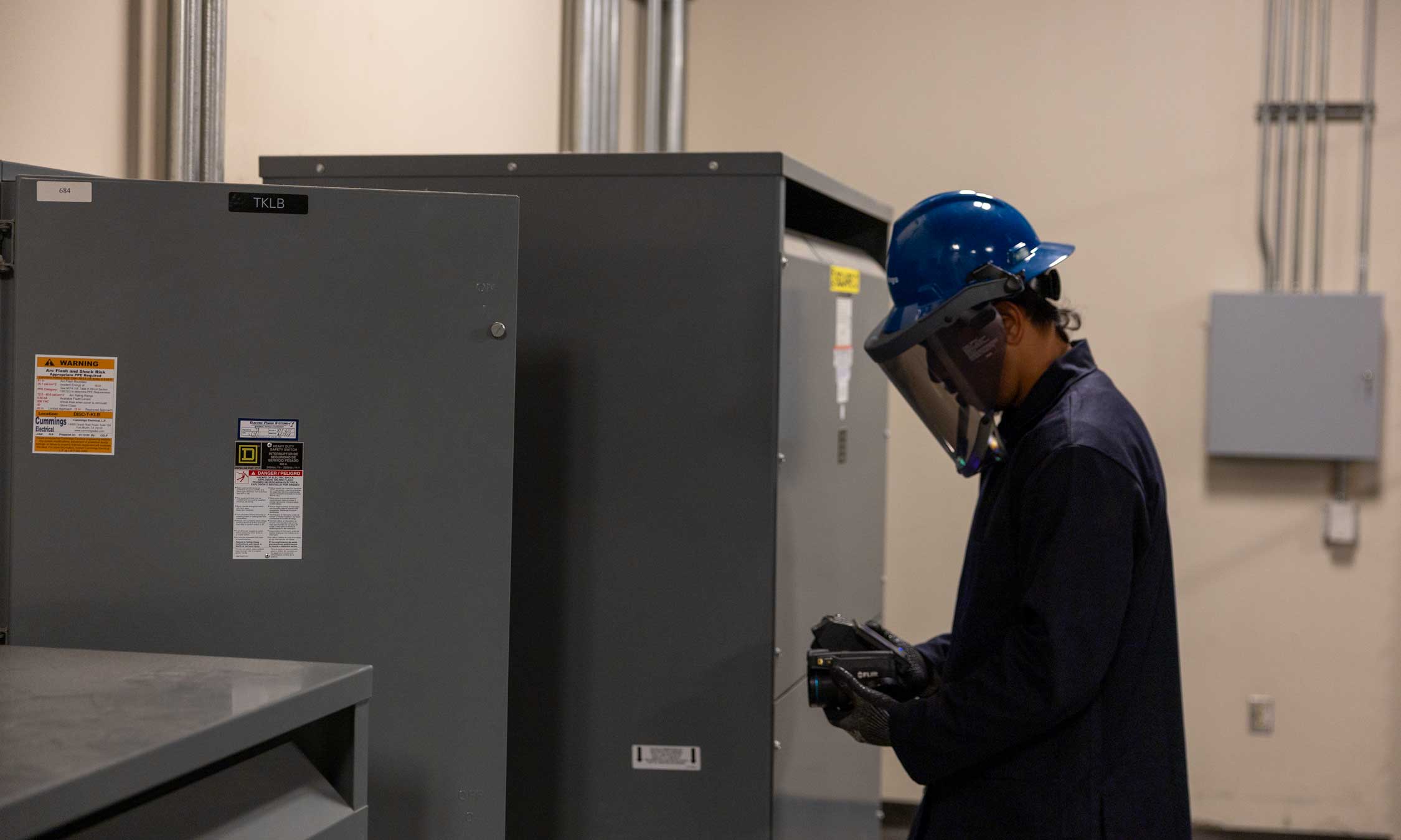 Electrician inspecting electrical panel inside airport facility