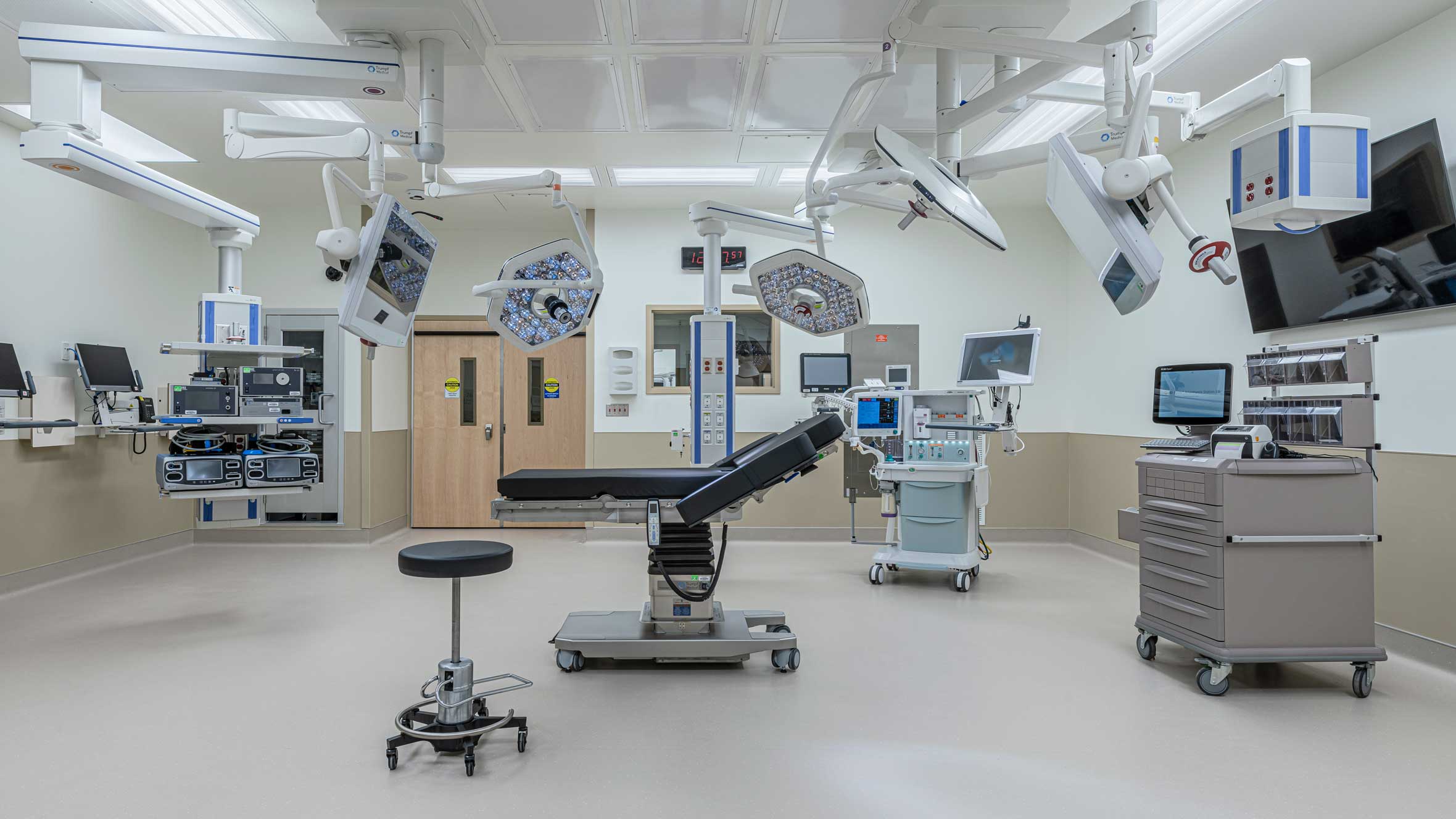Sterile hospital operating room with ceiling-mounted equipment and surgical lights