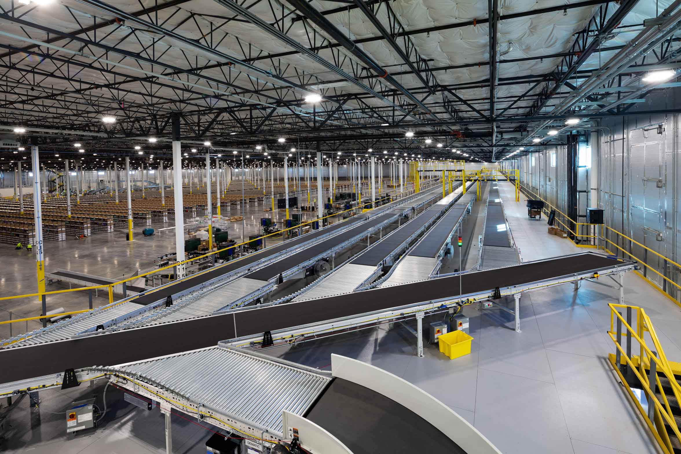 Interior of a large distribution facility with a complex conveyor system and extensive racking in the background