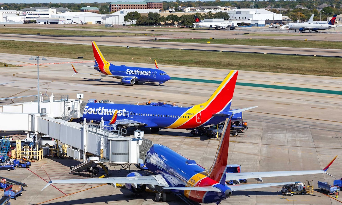 Southwest planes at an airport gate with ground crew in operation